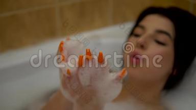 泡澡的年轻快乐女人，在泡沫中玩耍，放松浪漫的气氛